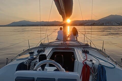 Couple sailing at sunset on private sailboat Marbella
