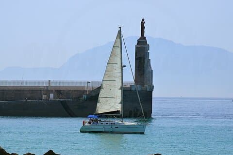 Sailboat leaving Tarifa port in the background can be seen Africa