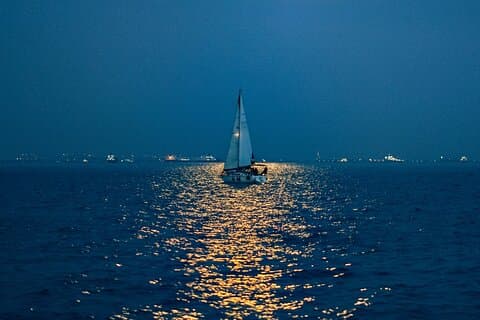Boat with wake bright full moon