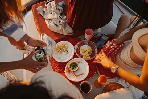 Unique sailing experience on the Costa del Sol: group enjoying a picnic on board sailing off Estepona. Quiet sailing, calm sea and Mediterranean flavours on the high seas.