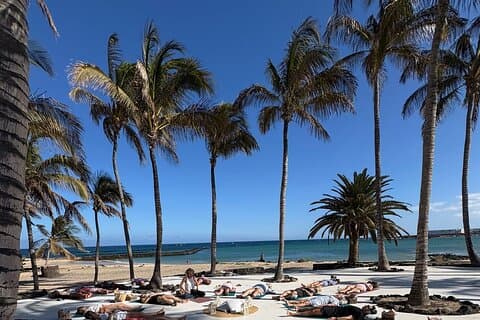 Yoga with headphones in front of the sea in Lanzarote