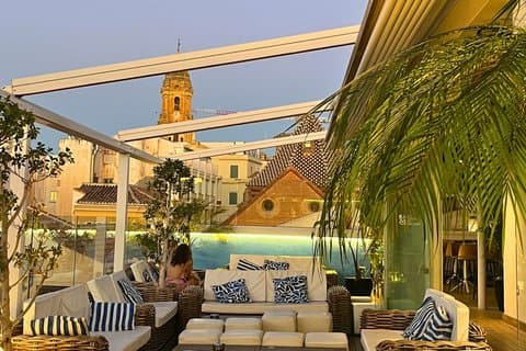 Relaxed rooftop setting where guests enjoy panoramic views and included drinks.