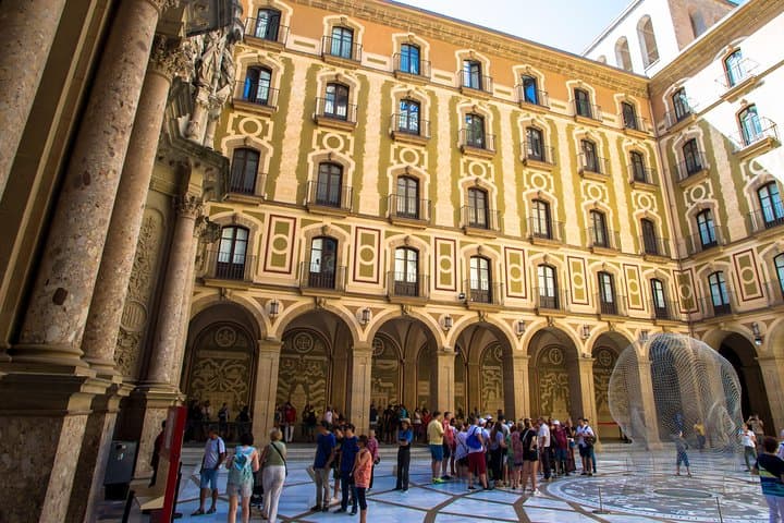 In thehttps://media-cdn.tripadvisor.com/media/attractions-splice-spp-720x480/08/3a/fb/e8.jpg courtyard outside the Basilica of Montserrat.