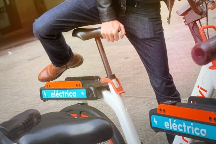 Man mounting one of the many shared e-mobility bikes in Barcelona