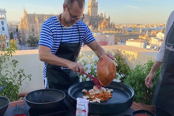 Mixing vegetables and rice on paella pan
