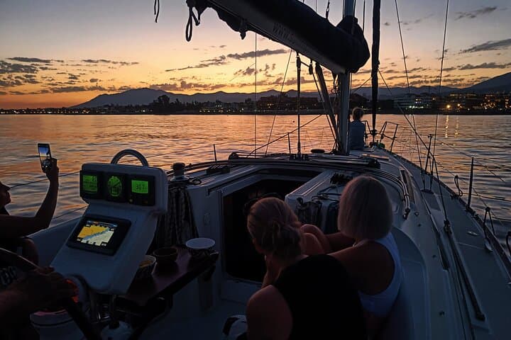 Group of friends at sunset on a private sailboat