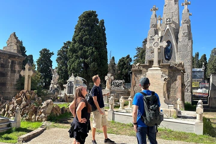 Tour guide explaining the history of the montjuic 
cemetery, graves, and the people buried there