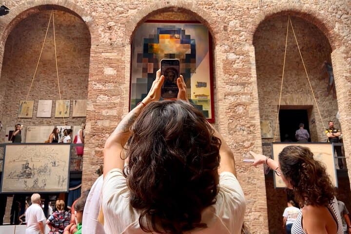 A visitor deciphers one of Dalí's works with her phone
