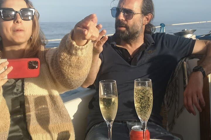 Enjoy a sunset from the sea with a cup of cava
