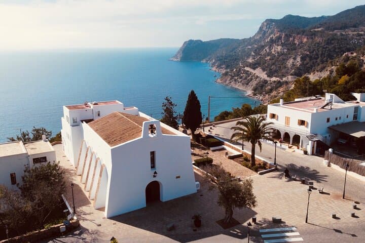 Second stop: The charming village of Es Cubells, where you’ll marvel at whitewashed houses, a quaint church, and dramatic cliffs offering panoramic views of the Mediterranean.