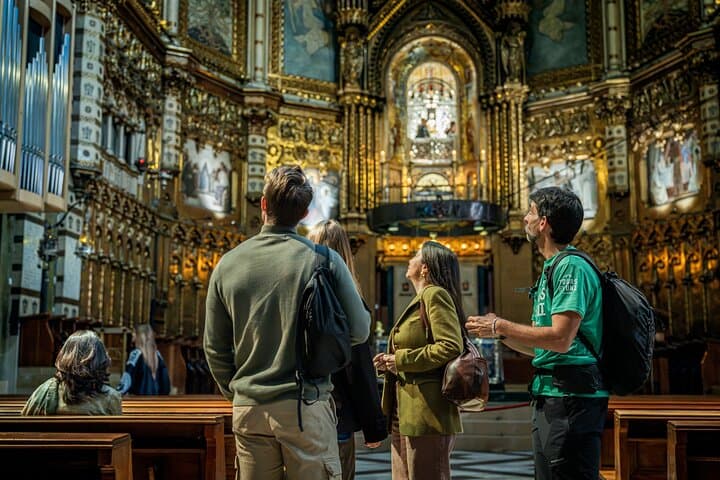 Visitors inside the Basilica of Montserrat marvel at the ornate altar and the revered Black Madonna statue during a guided cultural tour from Barcelona