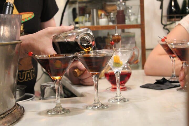 Homemade vermouth being poured into cocktail glasses