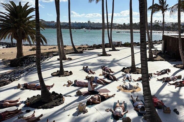 Yoga with headphones in front of the sea in Lanzarote