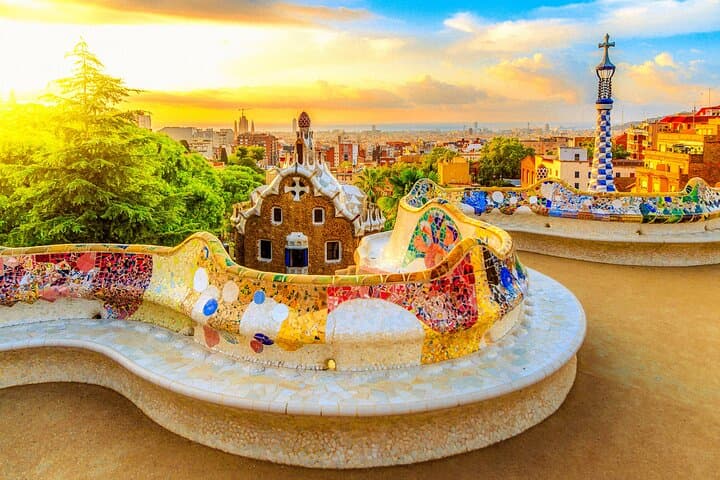 Relax on the famous serpentine bench of Park Güell, framed by vibrant mosaics and Barcelona’s skyline.
