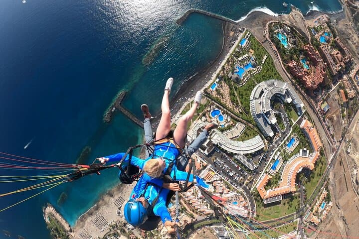Paragliding flying high above the coastline.