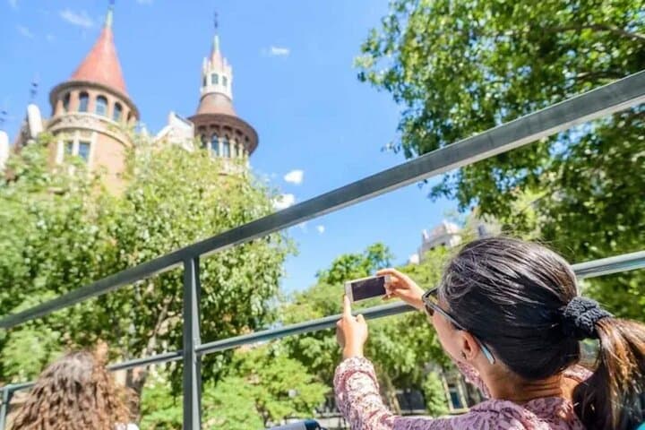 A traveler captures scenic city views from the vibrant Barcelona hop-on hop-off bus