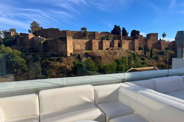 Rooftop views toward the Alcazaba fortress and surrounding hills.
