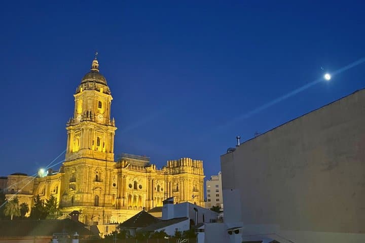 Evening views of Málaga Cathedral as the city lights begin to glow.
