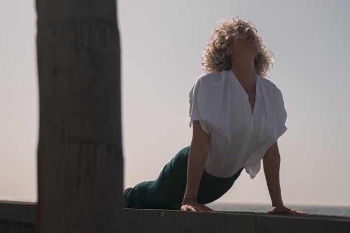 Yoga with headphones in front of the sea in Lanzarote