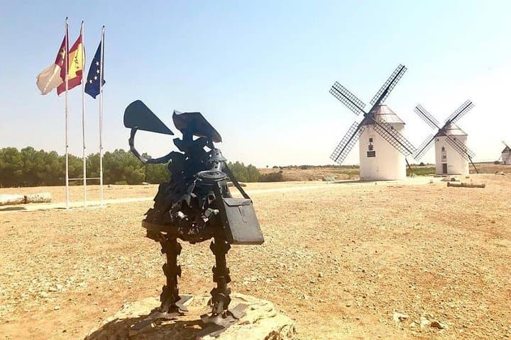 Statue of Sancho Panza drinking wine in front of the windmills