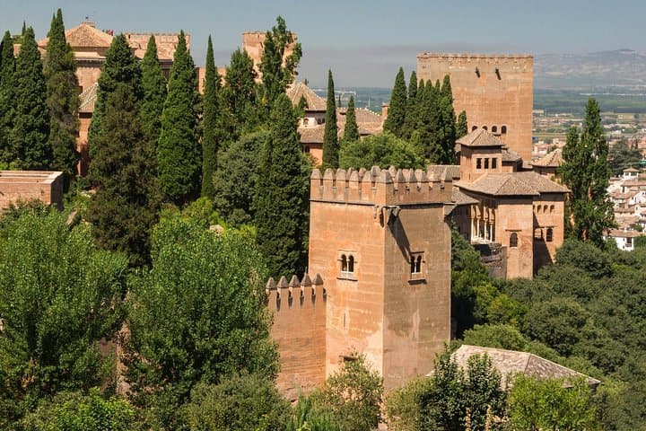 The Alhambra from the Generalife. The towers emerge from the vegetation.