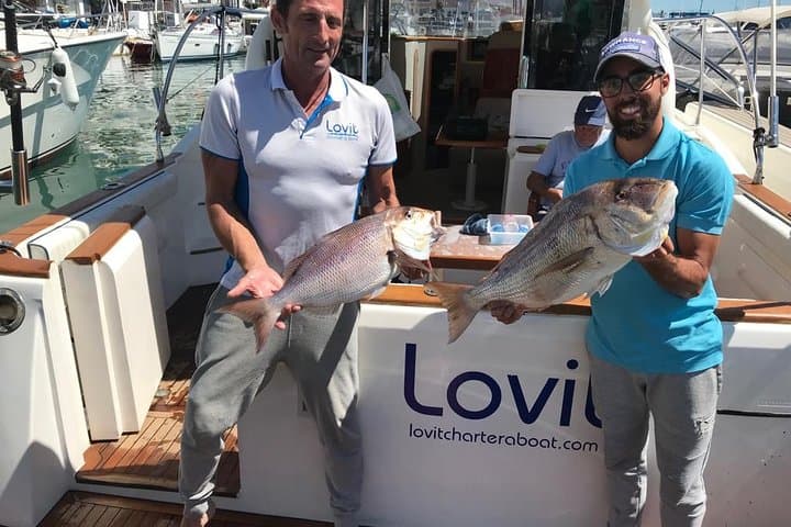Captain and sailor posing with 2 great catches. A great morning with satisfied customers. Boat fishing in Marbella