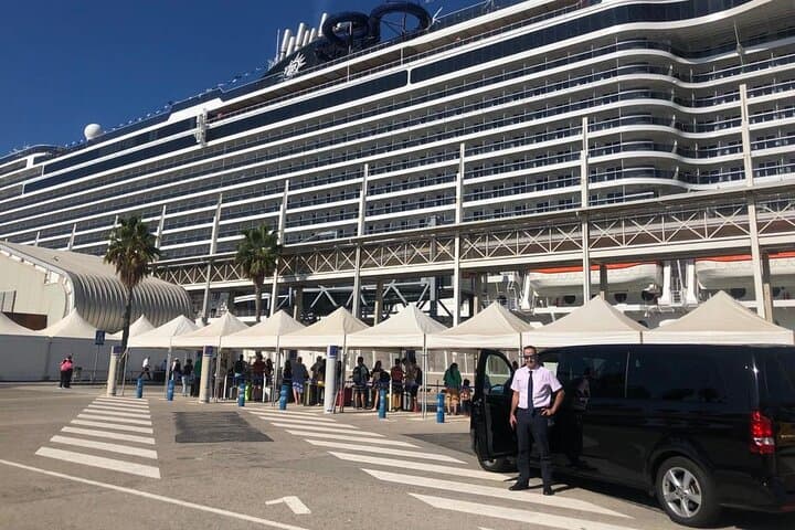 One of our chauffeurs and a van in front of a cruise at the Cruise Port.