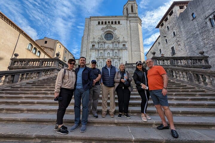 Group of tourists standing on the stairs of Girona Cathedral during a guided tour