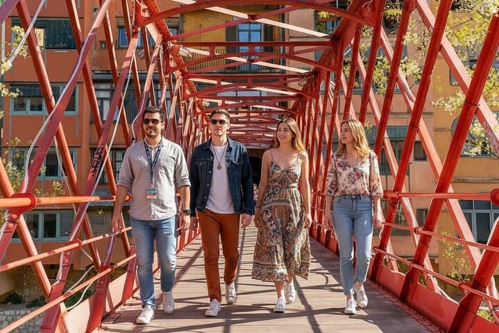 Visitors walking across a bridge in Girona with a tour guide